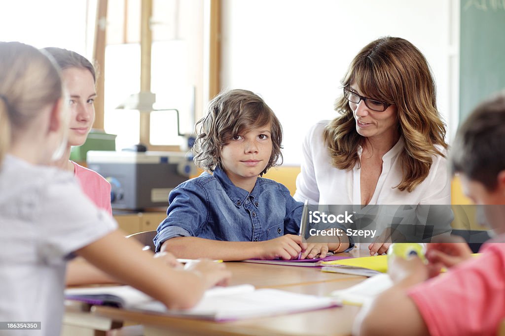 Teacher and student on a lesson. Teamwork in classroom at school. Adult Stock Photo