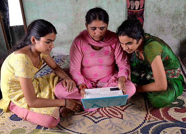 indian femme à l'aide d'un ordinateur portable avec ses filles - global village photos et images de collection