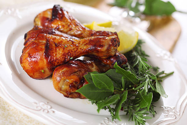 istock Roast chicken legs with lemon and herbs on plate. 186361068