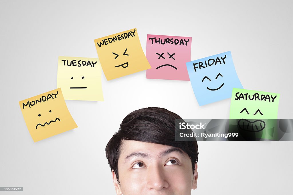 man looking stickers with week of face expression closeup of young man looking up with color stickers displaying day of week and face expression on each separate color, asian man Adhesive Note Stock Photo