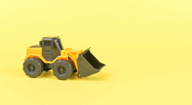 istock A yellow bulldozer with a large bucket on a yellow background. 1863625217