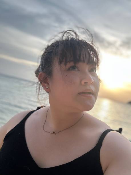 istock Pretty woman taking selfie and thinking on sunset at beach 1863629380
