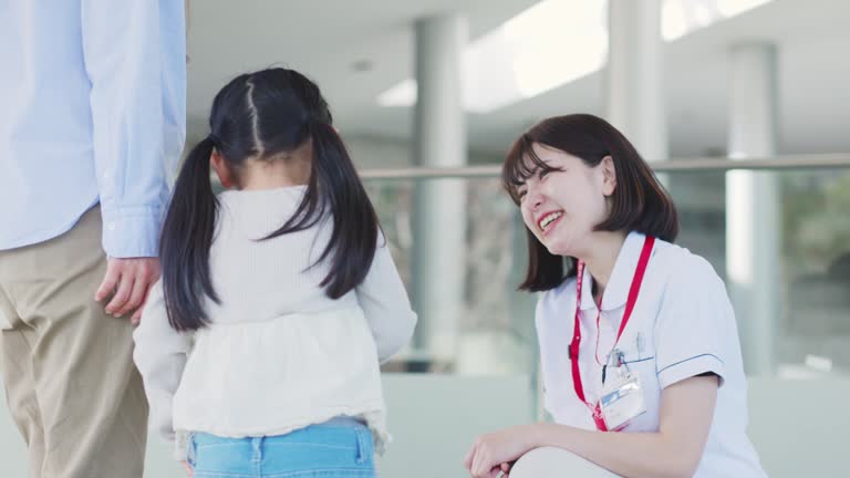 Smiling nurse and patient's child talking in the hospital