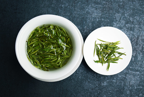 Image of tea set, Asian style with green tea leaves, tea set on the stone table