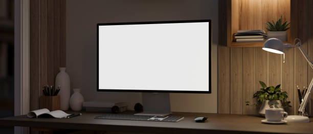 istock Modern office at night with a computer mockup and decor on a hardwood desk. Dark workspace 1863708345