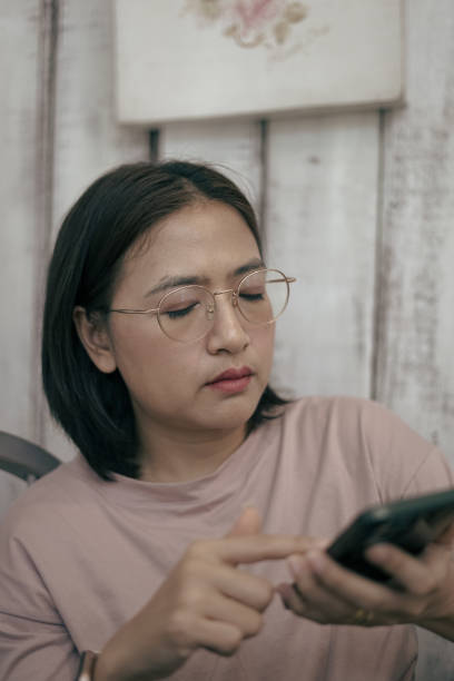 istock Woman sitting looking at mobile phone 1863778712
