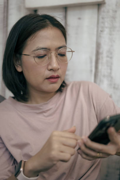 istock Woman sitting looking at mobile phone 1863778727
