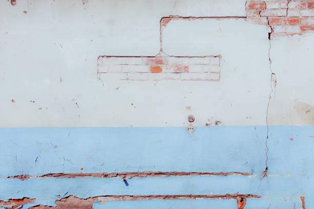 istock White and blue plaster on a dilapidated brick wall. Preparing the wall for repairs. 1863783888