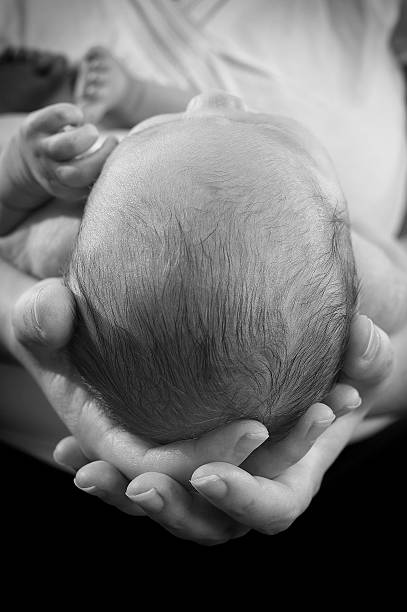 istock Mother holding baby head 186379882