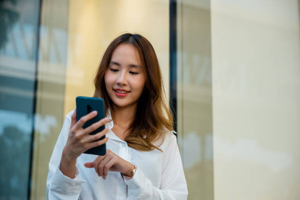 istock A woman in a white shirt using her smartphone for business 1863812505