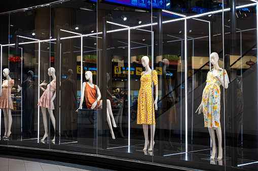 A display case full of mannequins showcasing diverse poses and styles for the fashion industry, Colorful and artistic mannequins in a store display case