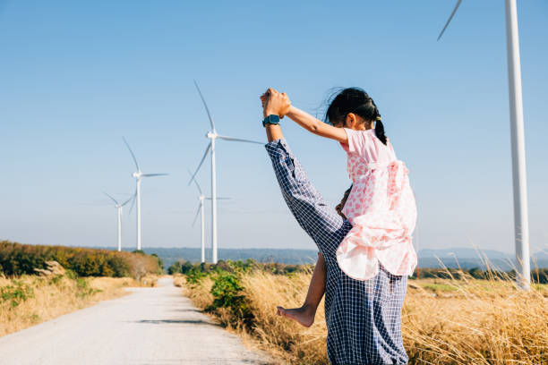 istock Father joyfully carries daughter exploring wind farm 1863813056