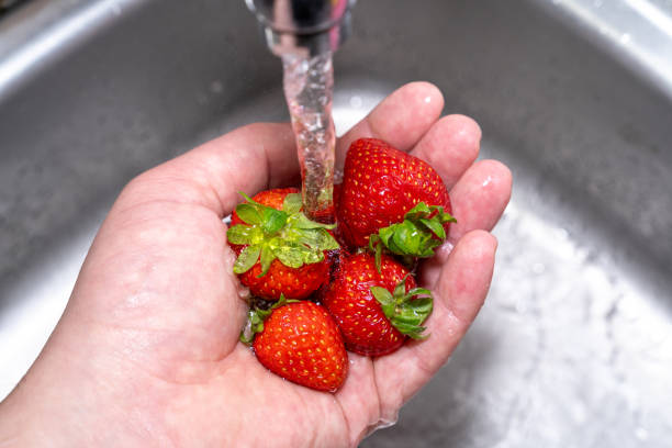 istock Hand with wet strawberries in the sink 1863823953