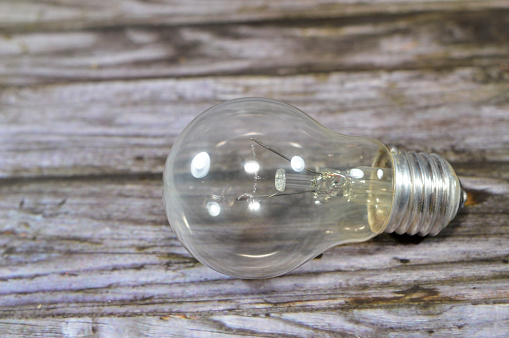 incandescent light globe bulb lamp, an electric light with a wire filament tungsten that is heated until it glows, consists of gas bulb, low pressure inert gas, Tungsten filament, wires, stem, cap, selective focus