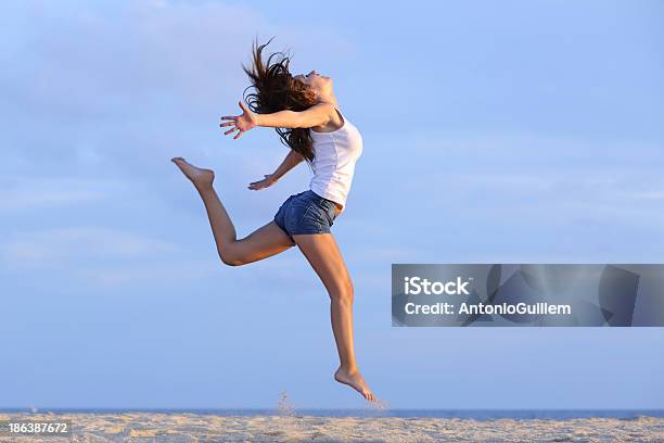 Woman Jumping On The Sand Of Beach Stock Photo - Download Image Now - Active Lifestyle, Activity, Adolescence