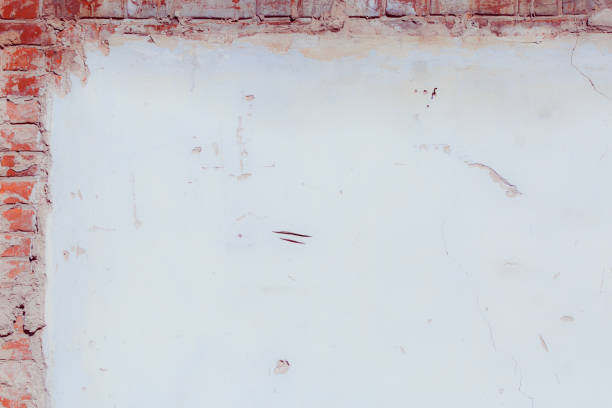 White plaster wall with deep scratches and chips. Various variations of abrasions.