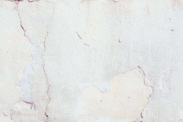 istock White plaster wall with deep scratches and chips. Various variations of abrasions. 1863892037