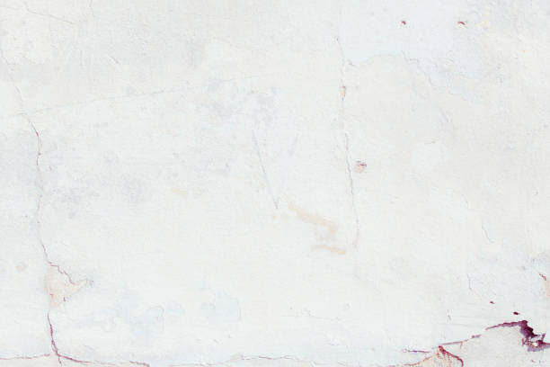 istock White plaster wall with deep scratches and chips. Various variations of abrasions. 1863892694