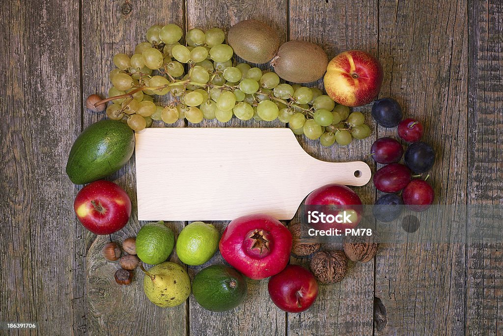 Vuoto Tagliere su uno sfondo in legno con frutta. - Foto stock royalty-free di Agricoltura