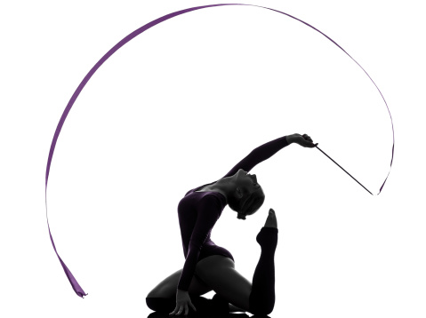 one caucasian woman exercising Rhythmic Gymnastics with ribbon in silhouette studio on white background