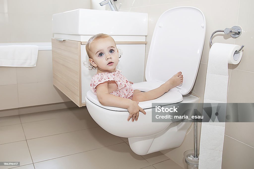 Little Child in Toilet Little Baby Girl trying to sitting on WC Child Stock Photo