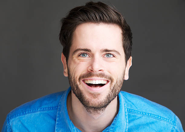 istock Casual young man laughing on gray background 186397062