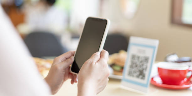 istock Woman use smartphone to scan QR code for order menu in cafe restaurant with a digital delivery. Choose menu and order accumulate discount. E wallet, technology, pay online, credit card, bank app. 1864037259