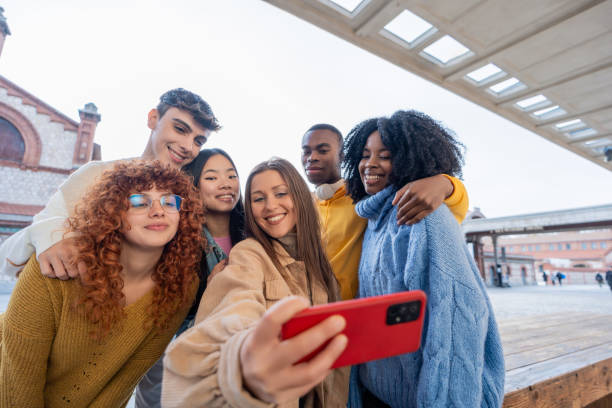 istock Multiethnic friends smiling while taking selfies with a mobile phone. 1864050704