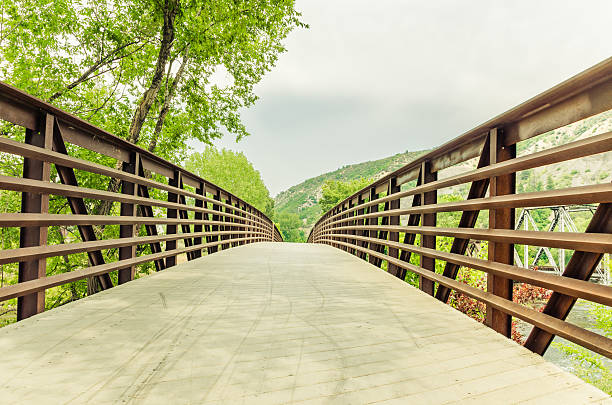 A pedestrian and bicycle bridge in a park in Durango, Colorado on a cloudy day