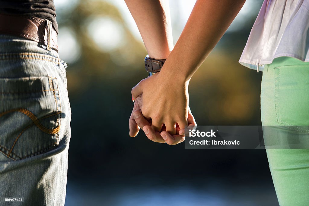 Couple Holding Hands A Young Couple Holding Hands In The Sunset Couple - Relationship Stock Photo