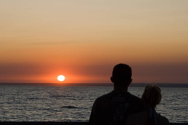 istock Silhouette man and woman again sunset 186408038