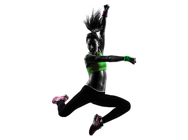 one caucasian woman exercising fitness zumba dancing jumping in silhouette on white background