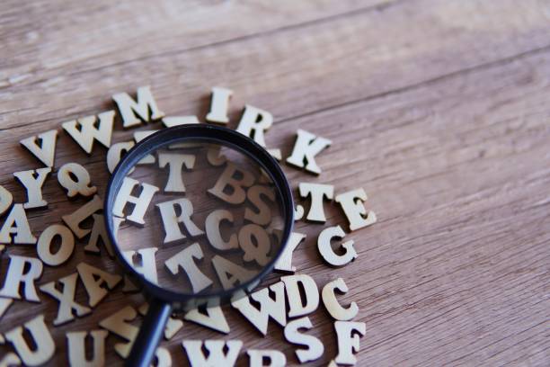istock Magnifying glass with scattered alphabet letters on the table. 1864083142