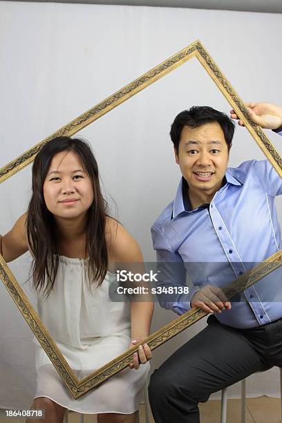 Foto de Asian Casal Posando Com Moldura De Quadro e mais fotos de stock de Abraçar - Abraçar, Amor, Asiático e indiano