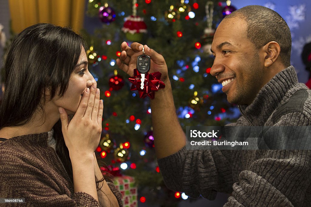 Man holds car keys as gift for holidays, horizontal Woman is happy receiving car for Christmas Car Key Stock Photo