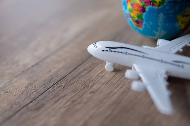istock Closeup image of toy plane and earth globe on table with copy space. 1864111621