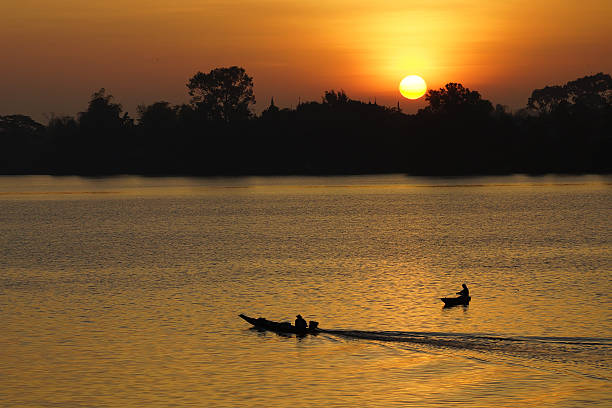 istock sunrise with boat and fisherman 186411203