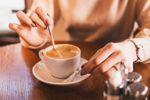 istock A girl drinks latte coffee at a wooden table. 1864112200
