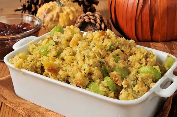 A baking dish of cornbread stuffing with celery and turkey bits
