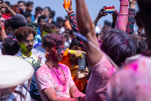 Varanasi, Uttar Pradesh, India - March 2023: Masan holi, Group of people celebrating the festival of holi at manikarnika ghat with colours.