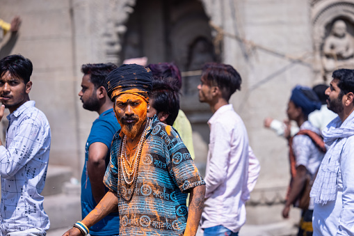 Varanasi, Uttar Pradesh, India - March 2023: Masan holi, Group of people celebrating the festival of holi at manikarnika ghat with colours.