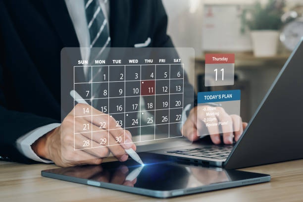 istock Time management concept.Businessman manages time for Work planning increases efficiency on Calendar app.Highlight appointment reminders and meeting agendas.Virtual screen interface. 1864125422