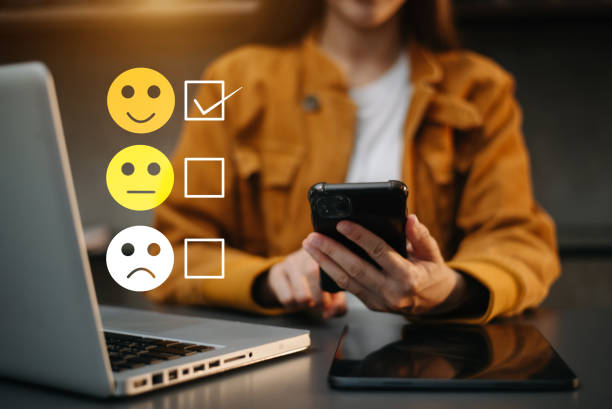 istock Customer service evaluation concept. woman Show face smile emoticon show on virtual screen from hand.looking at smart phone, tablet and laptop 1864126525