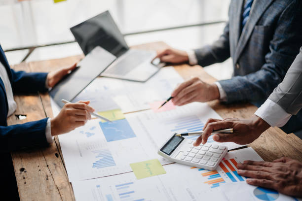 istock Business People Talking Discussing with financial document data charts and graphs Team business meeting with smart phone and laptop and digital tablet computer 1864127066