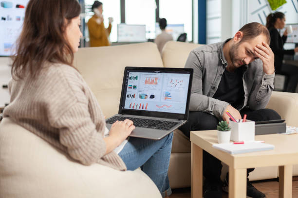 istock Business woman sitting on couch in office using laptop 1864135217