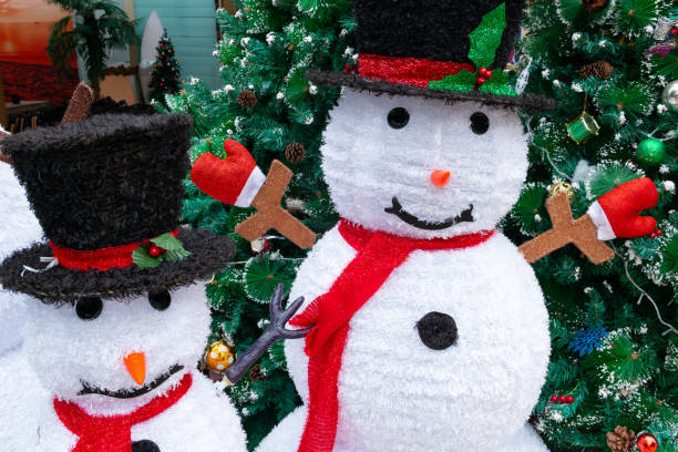 istock two snowmen nearby fir-tree at horizontal composition 1864139442