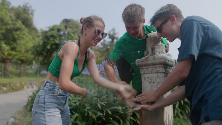 Teenagers washing refreshing at the fountain in public park