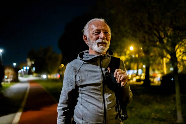 Senior man in the city during late evening walk.