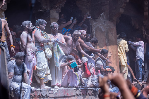 Varanasi, Uttar Pradesh, India - March 2023: Masan holi, Group of unidentified people celebrating the festival of holi at manikarnika ghat with rituals. Manikarnika ghat is a cremation point.