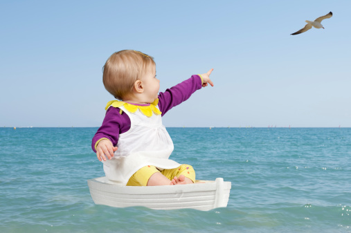 summertime : little toddler in a boat on the ocean